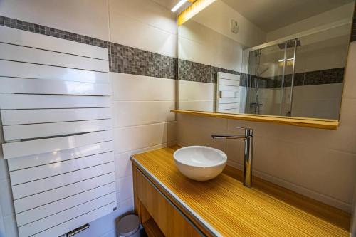 ein Badezimmer mit einem weißen Waschbecken und einem Spiegel in der Unterkunft Résidence L'ecrin - ECRIN A22 MAE-0131 in Arc 1800