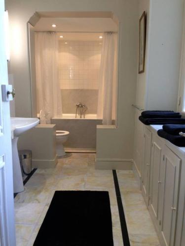 a bathroom with a tub and a toilet and a sink at B&B Le Jardin de Carco in Châtillon-sur-Seine