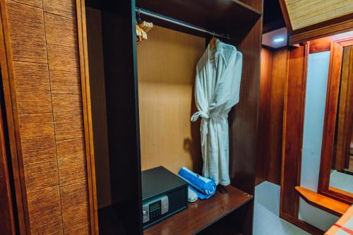 a small room with a bed and a dresser in a bedroom at Millennium in Fuvahmulah
