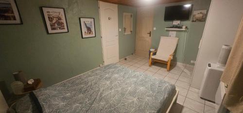 een slaapkamer met een bed en een stoel bij Studio Tranquillo avec piscine et salle de sport in Istres