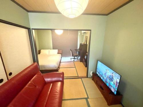Una sala de estar con un sofá y un televisor. en 抹茶庵伏見京都 Matcha-An Fushimi Kyoto, en Kioto