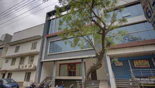 a building with a tree in front of it at Super Townhouse Townhouse Atal Chowk Indirapuram Ghaziabad in Ghaziabad