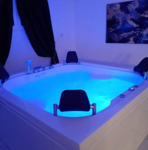 a bath tub with two chairs sitting in it at Meteora Grande luxury suite & spa villa in Kalabaka