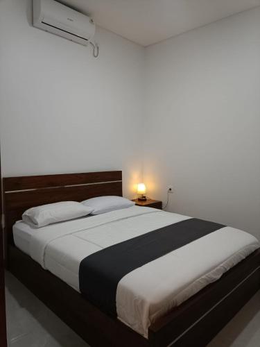 a bedroom with a large bed with a black and white blanket at Rauda Living Space Syariah in Pasuruan