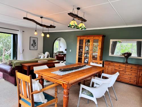 une salle à manger avec une table en bois et des chaises blanches dans l'établissement Fish Eagle Cottage, 