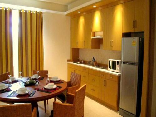 a kitchen with a table with chairs and a refrigerator at Hua Hin Blue Lagoon in Cha Am