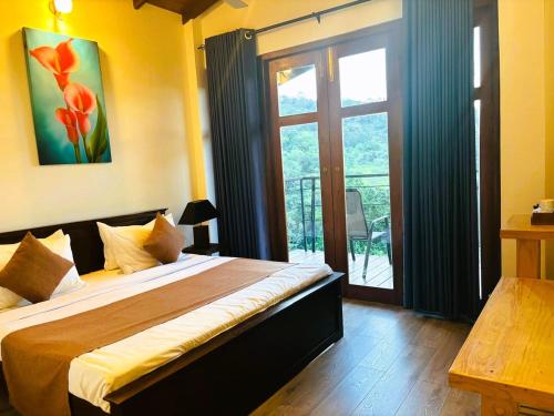 a bedroom with a large bed and a balcony at Benjamin Cottage Haputale in Haputale