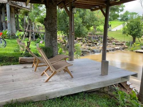 two chairs sitting on a wooden deck under a pavilion at Luxury Treehouse Khaoyai in Ban Nong Makha