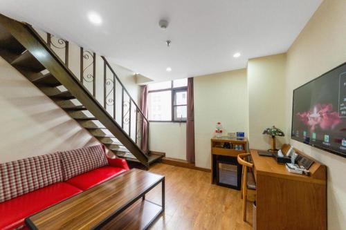 a living room with a red couch and a staircase at James Joyce Coffetel Xi'an Lingtong The Terracotta Army Huaqingchi University Town Metro Station in Xi'an