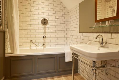een badkamer met 2 wastafels en een bad bij Dartbridge Inn by Greene King Inns in Buckfastleigh