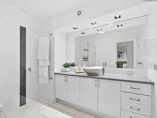a white bathroom with a sink and a mirror at Yarrawonga Lakeside Apartment 25 in Mulwala