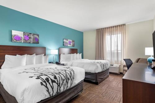 a hotel room with two beds and a desk at Sleep Inn Lancaster Dallas South in Lancaster