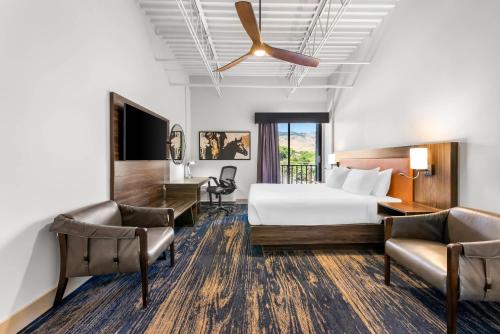 a hotel room with a bed and two chairs at The Federal Hotel Downtown Carson City, an Ascend Collection Hotel in Carson City