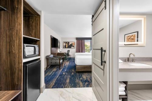 a hotel room with a bathroom with a sink and a bed at The Federal Hotel Downtown Carson City, an Ascend Collection Hotel in Carson City