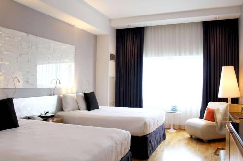 a hotel room with two beds and a chair at Radisson Blu Mall of America in Bloomington