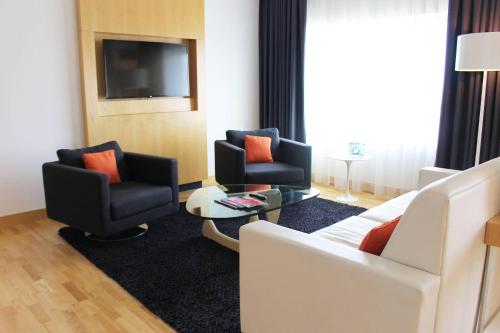 a hotel room with two chairs and a couch and a tv at Radisson Blu Mall of America in Bloomington