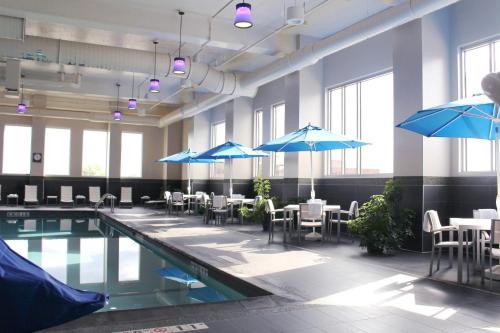 a pool with tables and umbrellas in a building at Radisson Blu Mall of America in Bloomington