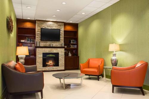 a waiting room with chairs and a fireplace at Country Inn & Suites by Radisson Nashville Airport TN in Nashville