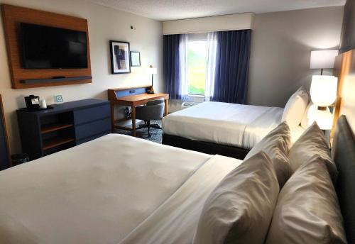 a hotel room with two beds and a desk and a television at Country Inn & Suites by Radisson, Dahlgren-King George, VA in Dahlgren