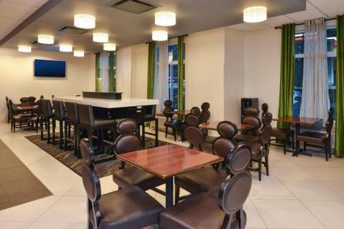 una sala de espera con piano, mesas y sillas en Country Inn & Suites by Radisson Nashville Airport TN, en Nashville