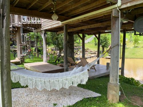 a hammock under a pavilion next to a river at Luxury Treehouse Khaoyai in Ban Nong Makha