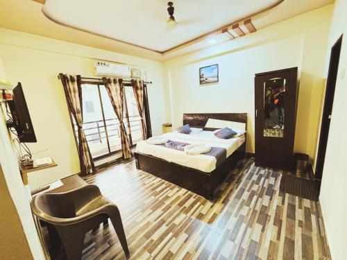 a bedroom with a bed and a chair in it at Anant Villa & Resorts in Nagaon