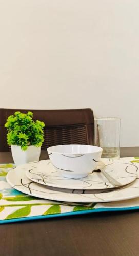 a table with two white bowls and plates on it at Luxury Rose hotel in Mussoorie