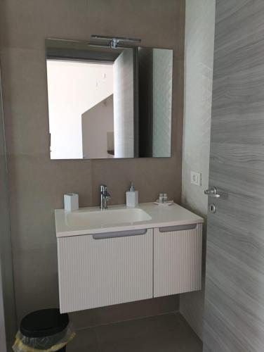 a bathroom with a white sink and a mirror at Dara Holiday Apartments in Marsala