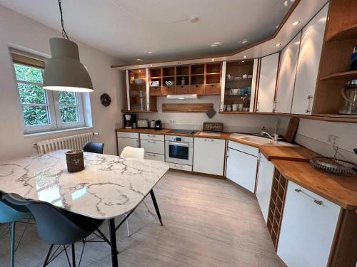 a kitchen with a table and a dining room at Cozy Wohnung fuer 4 Gaeste mit Terrasse unter Reet in Sankt Peter-Ording