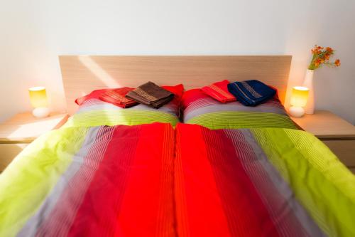 a bed with a colorful blanket on top of it at Apartments Marilyn in Tatranská Lomnica