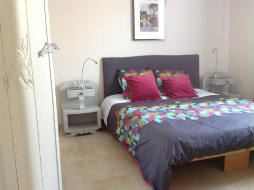 アヴィニョンにあるMaison du Parcのベッドルーム1室(ピンクと紫の枕が付いたベッド1台付)