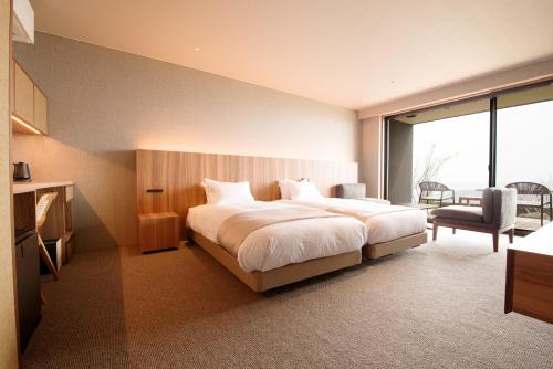 a bedroom with a large white bed and a chair at 山人 Oga in Oga