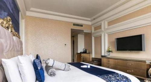 a hotel room with a bed and a flat screen tv at Hohhot Inner Mongolia Hotel in Hohhot