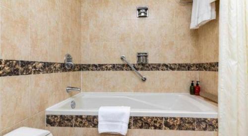 a bath tub in a bathroom with a toilet at Hohhot Inner Mongolia Hotel in Hohhot