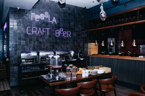 a restaurant with a bar with a table and chairs at Hotel Fessla in Kostanay