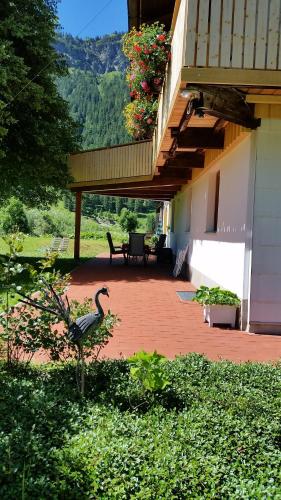 a patio with a bird standing on a brick yard at Haus Bilgeri in Nesselwängle