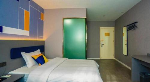 a bedroom with a large bed and a green door at 7 Days Inn Xi'an Railway Station in Xi'an