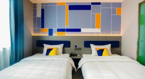 two beds sitting next to each other in a bedroom at 7 Days Inn Xi'an Railway Station in Xi'an
