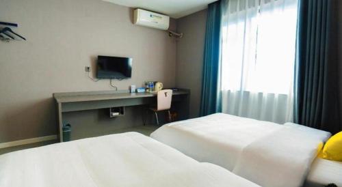 a hotel room with two beds and a television at 7 Days Inn Xi'an Railway Station in Xi'an