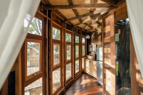 a room with large windows in a house at Luxury Treehouse Khaoyai in Ban Nong Makha