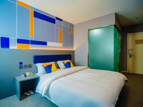 a bedroom with a large bed and a colorful wall at 7 Days Inn Xi'an Railway Station in Xi'an