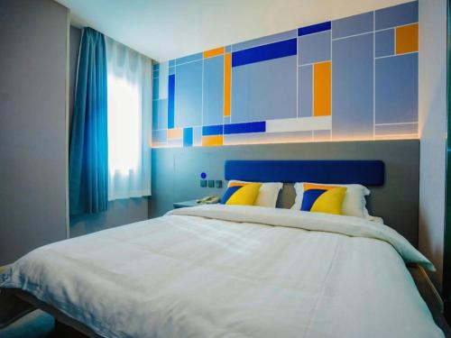 a bedroom with a large bed with a colorful wall at 7 Days Inn Xi'an Railway Station in Xi'an