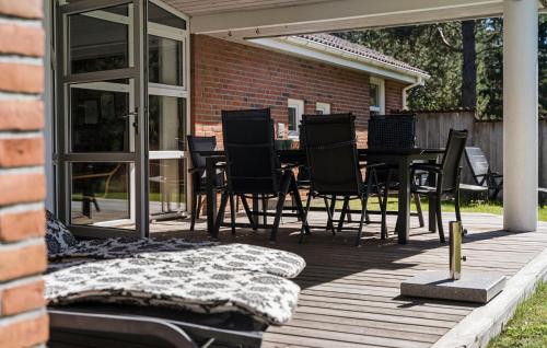 a patio with a table and chairs on a deck at Holiday Home Kærhøgen Rømø Denm in Rømø Kirkeby