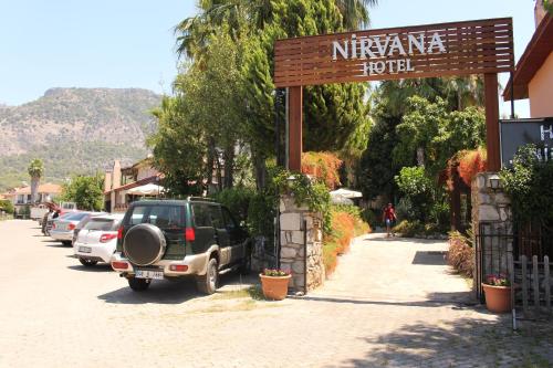 ギョジェクにあるNirvana Hotelの路上に駐車したSUVとホテルの看板