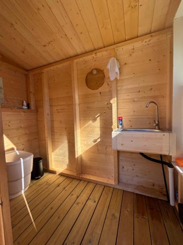 una sauna in legno con vasca e lavandino di Lakeside Glamping a Vossevangen