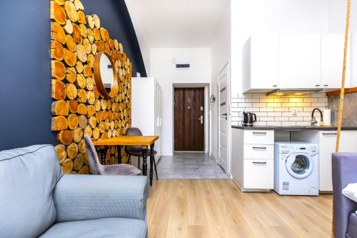 a living room with a couch and a kitchen at Rently Apartments in Old Town in Kraków