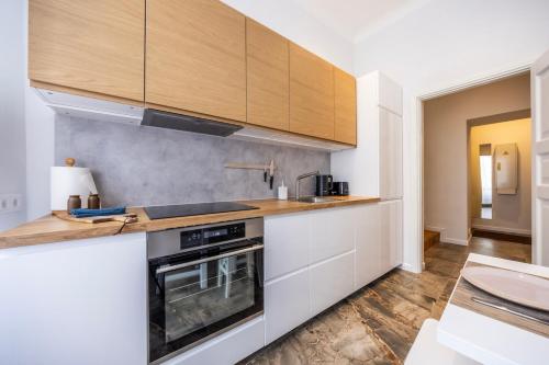a kitchen with white counters and wooden cabinets at 74m2 Newly renovated lux furnished Old town in Tallinn