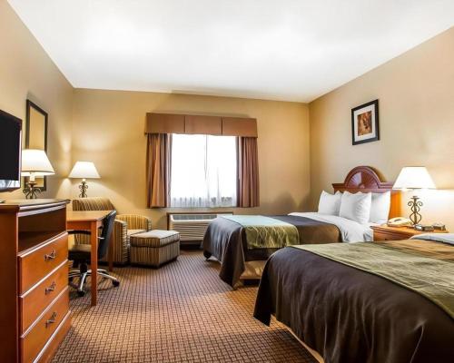 a hotel room with two beds and a desk at Quality Inn in Sidney
