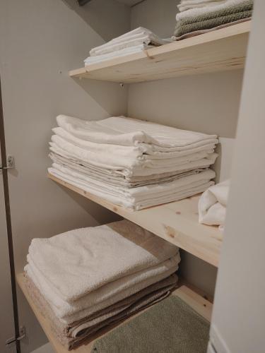 a pile of towels on a shelf in a closet at Rauhallinen majoitus parvekkeella in Joensuu