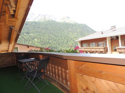 a balcony with a chair and a table and a mountain at Pension Winnebach in Längenfeld